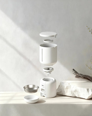 An exploded view of the components of a white smart cat feeder with a camera.